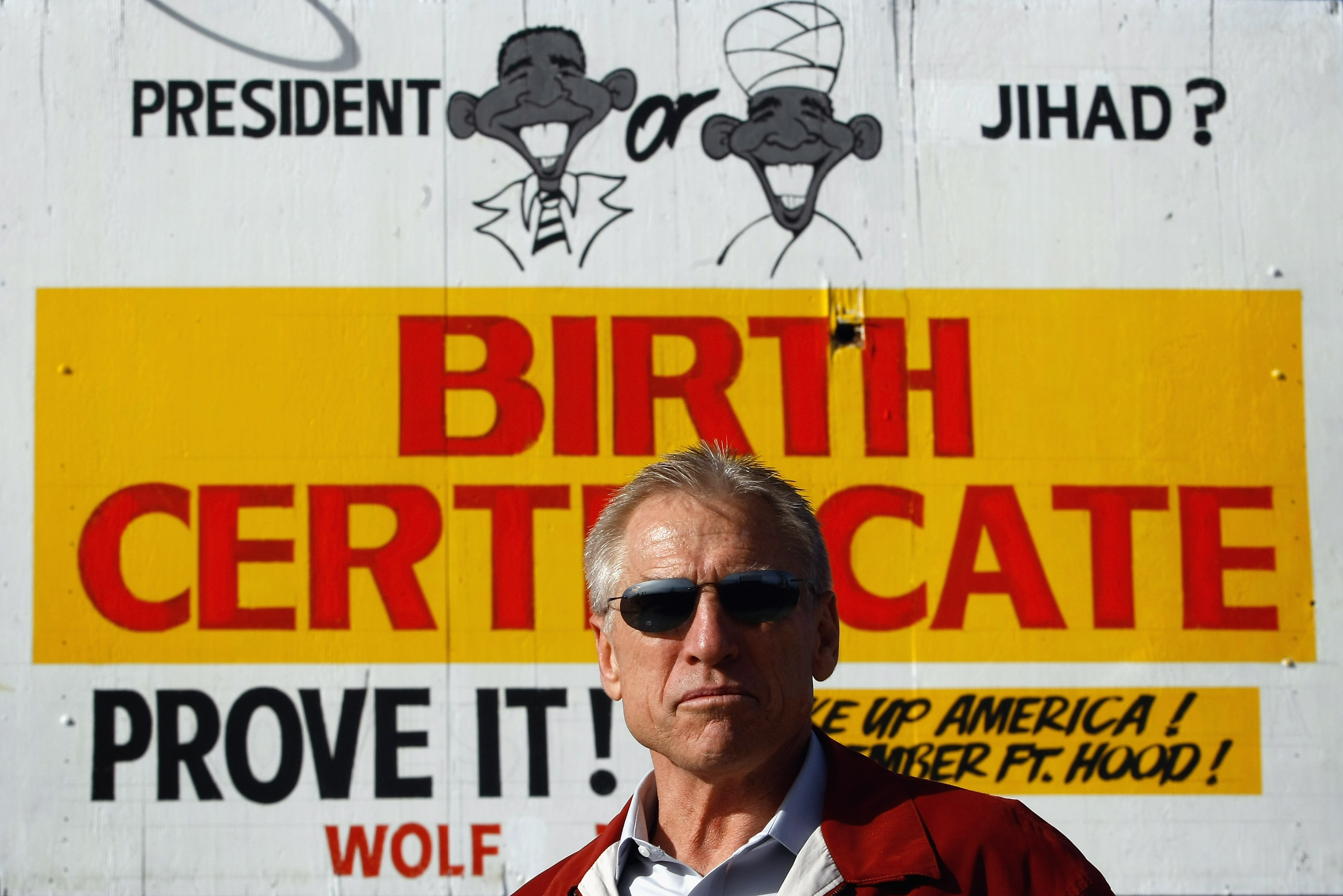 A Colorado businessman proudly stands in front of the billboard he erected outside of his used-car dealership that succinctly summarizes the “birtherism” conspiracy theory. Dating back to the 2008 campaign, the erroneous belief that Barack Obama was born abroad and so was ineligible to run for or serve as U.S. president reemerged with the rise of the Tea Party movement. False charges that the first Black president was a “crypto-Muslim,” born in Kenya and educated in Indonesian Islamic schools, became a staple of right-wing media, Tea Party election campaigns, and demonstrations opposed to the Affordable Care Act. By the middle of the Obama presidency, Donald Trump became the most visible “birtherism” proponent, demanding to see the president’s birth certificate.