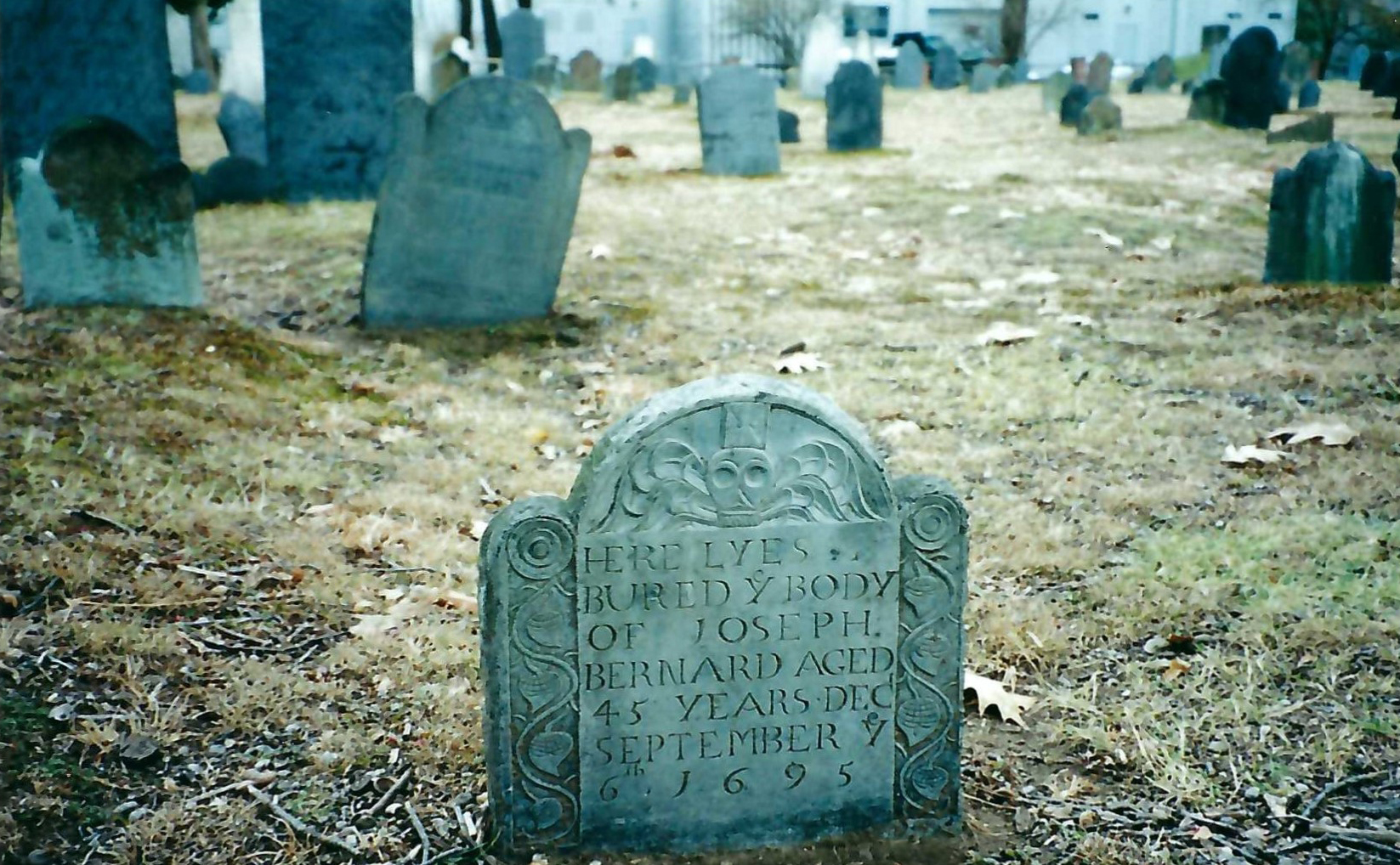 Since the seventeenth century, many grave markers have become illegible due to weather or other damage. The gravestone in foreground reads “Here lyes buried the body of Joseph Bernard, aged 45 years, dec [deceased] September 6th 1695.”