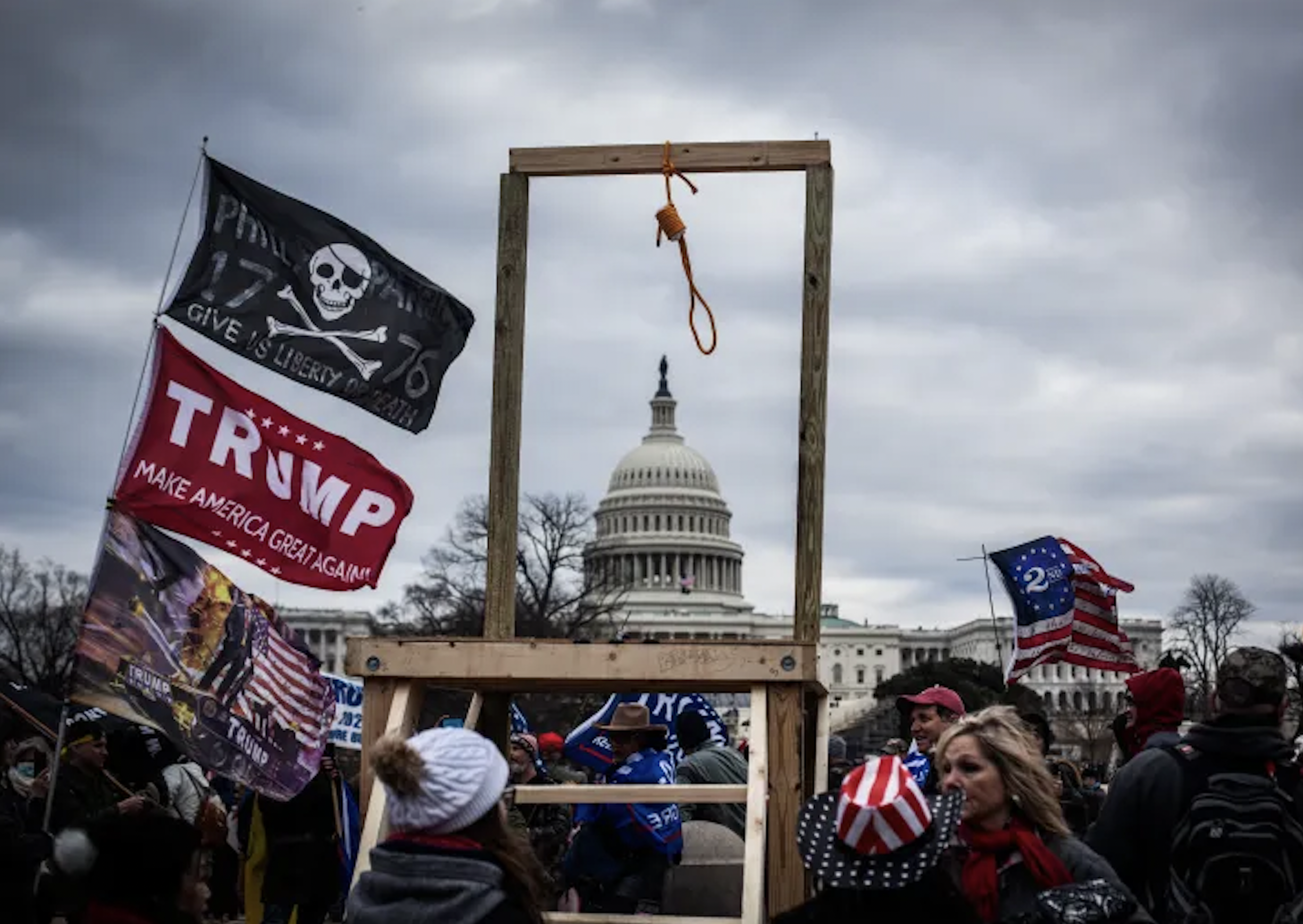 Surrounded by banners (including one with the Trump campaign slogan “Make America Great Again” or “MAGA”), a gallows erected by the defeated incumbent’s supporters frames the U.S. Capitol, warning of the fate in store for Vice President Mike Pence if he refuses to challenge Congress’s certification of Joe Biden's victory in the 2020 election. Incited by Trump’s and allies’ call to “Stop the Steal” at a rally near the White House, hundreds of protesters stormed the Capitol, overwhelmed police, and invaded the building. The joint session of Congress was halted as senators and representatives were forced to seek shelter. At 3:42 the following morning, the reconvened proceedings affirmed the election results certifying Biden as the forty-sixth president.