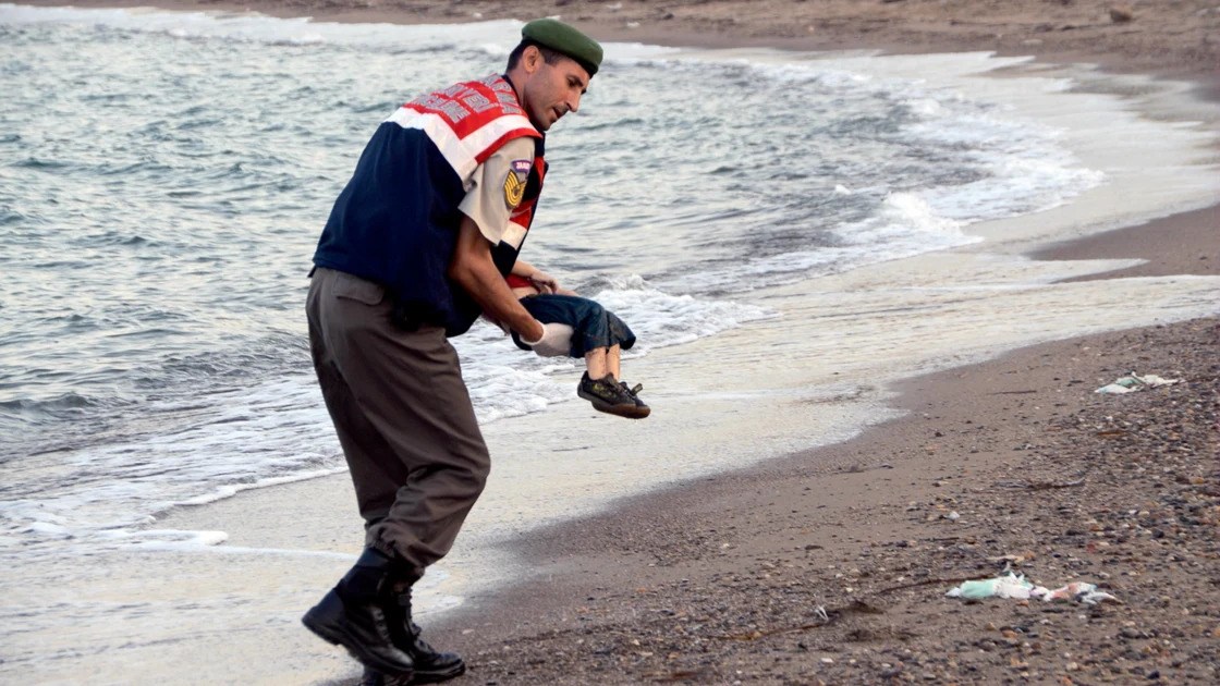 In September 2015, a police officer carried a child’s body, which had washed up near a southern Turkish port city. With his Kurdish family, three-year-old Aylan Kurdi had fled from the Syrian civil war, hoping to reach the Greek island of Kos. Filled with refugees, the boat they were on sank in the Aegean Sea, taking Aylan and his older brother and mother. Photographs of the child’s lifeless body—this is the least graphic in a series—appeared on the front pages of newspapers and on news broadcasts across the world and on the internet. It was a grim testament to the refugee crisis and a condemnation of the failure of the United States and European nations to address the flood of asylum seekers fleeing conflicts and repression in the Middle East and Africa.