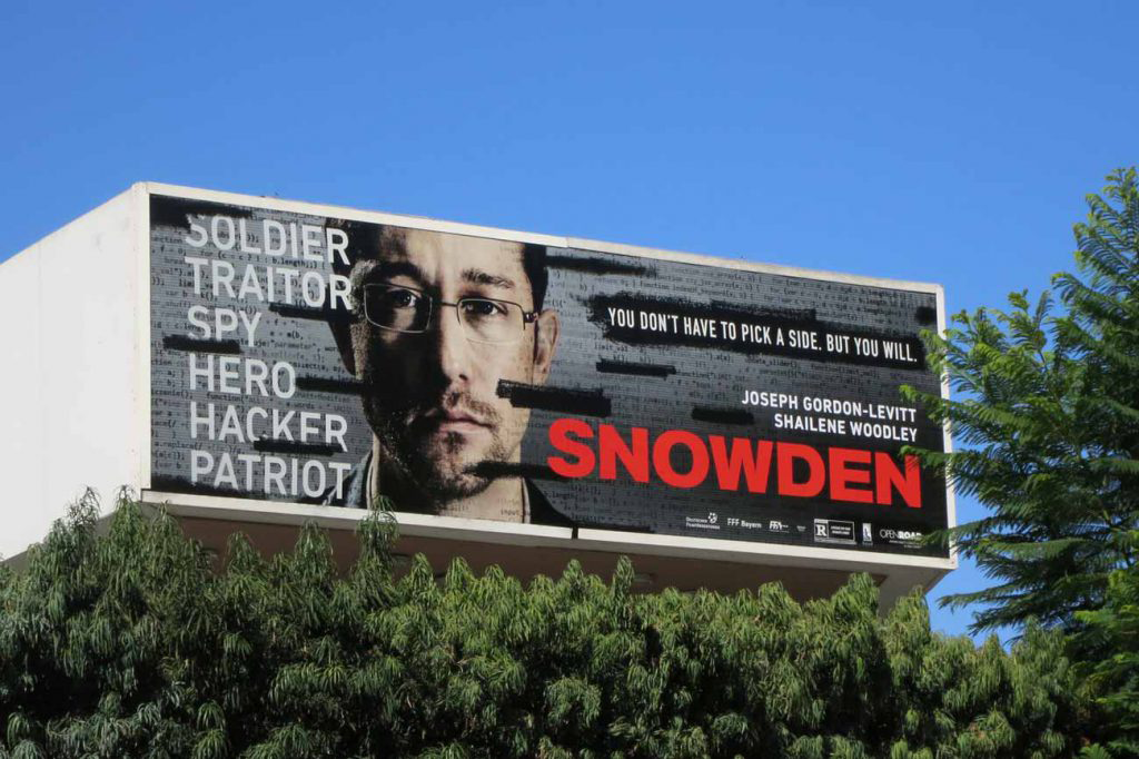 A billboard in Hollywood advertising the 2016 biographical film <em>Snowden</em> succinctly presents Edward Snowden’s complicated status in the public eye after the former CIA analyst leaked classified data from the U.S. government’s National Security Agency three years earlier. Ignored when he tried to get the agency to address the ethical issues and legal violations underlying its unconstitutional secret invasion of Americans’ privacy (in cooperation with U.S. communications companies and foreign governments), Snowden released classified documents via numerous news outlets. They revealed the sweeping and global extent of the NSA’s surveillance program. Viewed by many as a selfless advocate for transparency and personal rights and by others as a traitor and spy, Snowden’s disclosures sparked renewed debate about and legislation addressing national security and individual rights. The U.S. Department of Justice charged Snowden with stealing government property and violating the 1917 Espionage Act. After the indictments, Snowden fled to Russia.