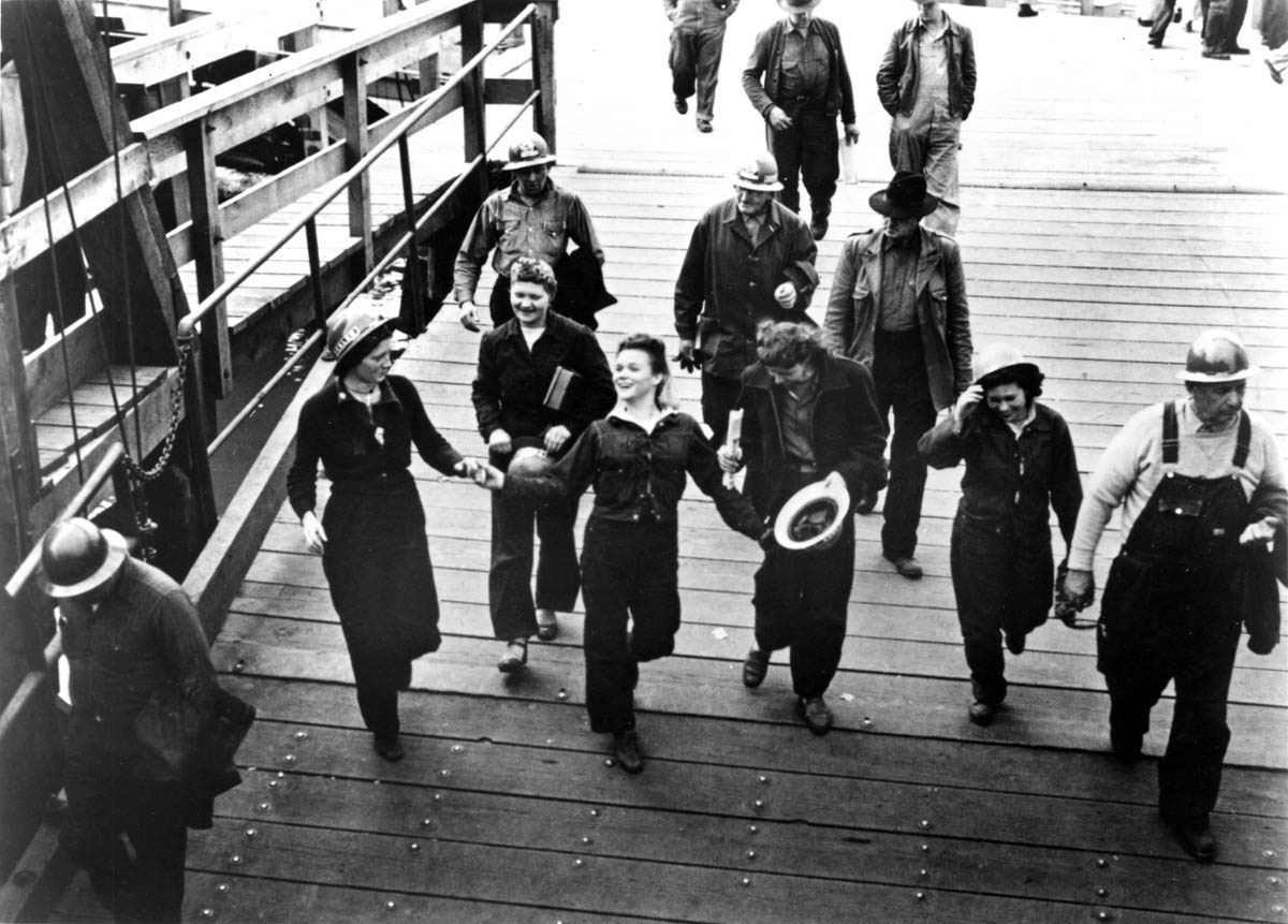 Men and women workers begin to unwind as they finish their shift in a Richmond, California, shipyard.