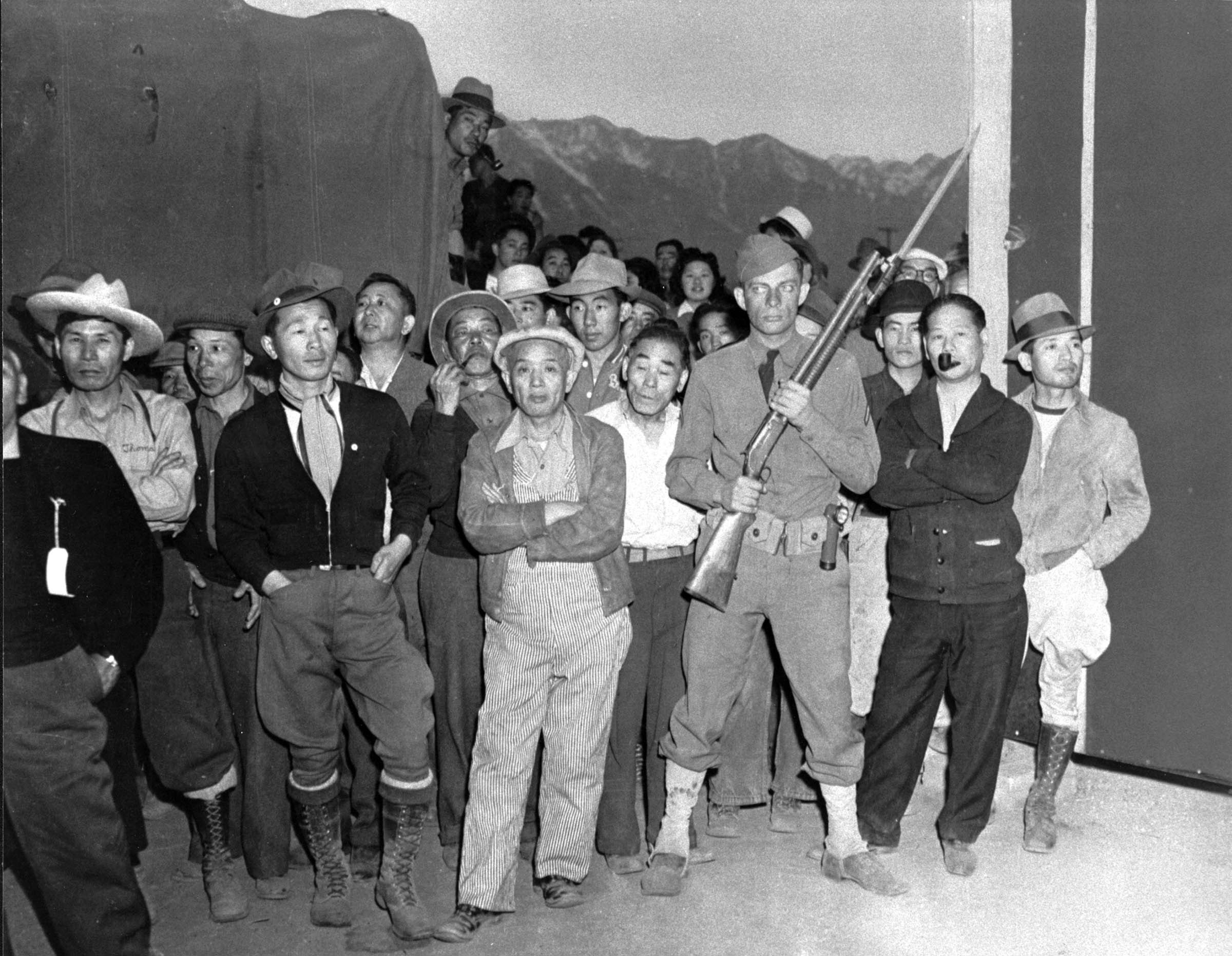 These Japanese Americans in the newly opened California internment camp had gathered to watch the arrival of fellow internees.