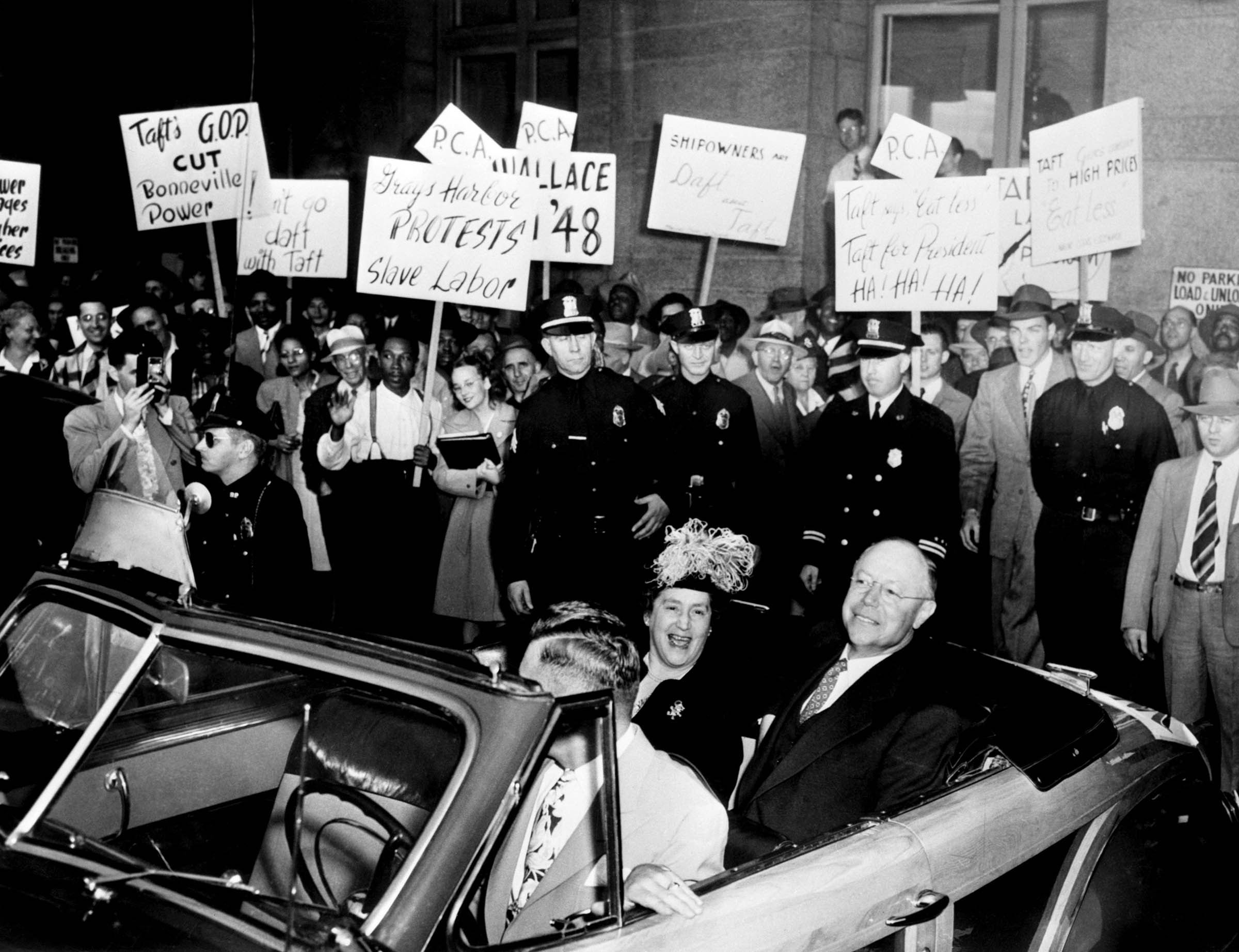 Ohio Republican Senator Robert Taft, cosponsor of the Taft-Hartley Act, is confronted by trade union demonstrators in Seattle, Washington, in August 1947.