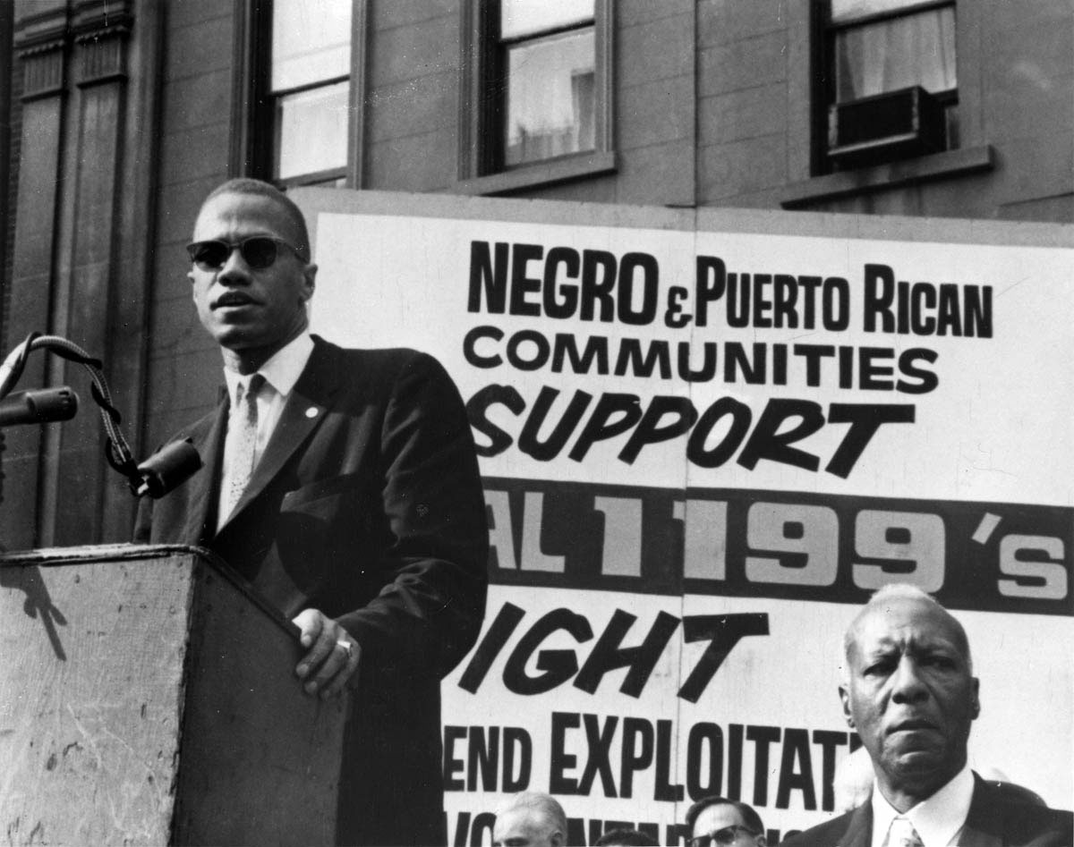 Malcolm X and trade union leader A. Philip Randolph share a platform during a 1962 rally celebrating a successful hospital workers’ strike organized by Local 1199 of the Drug and Hospital Employees’ Union.