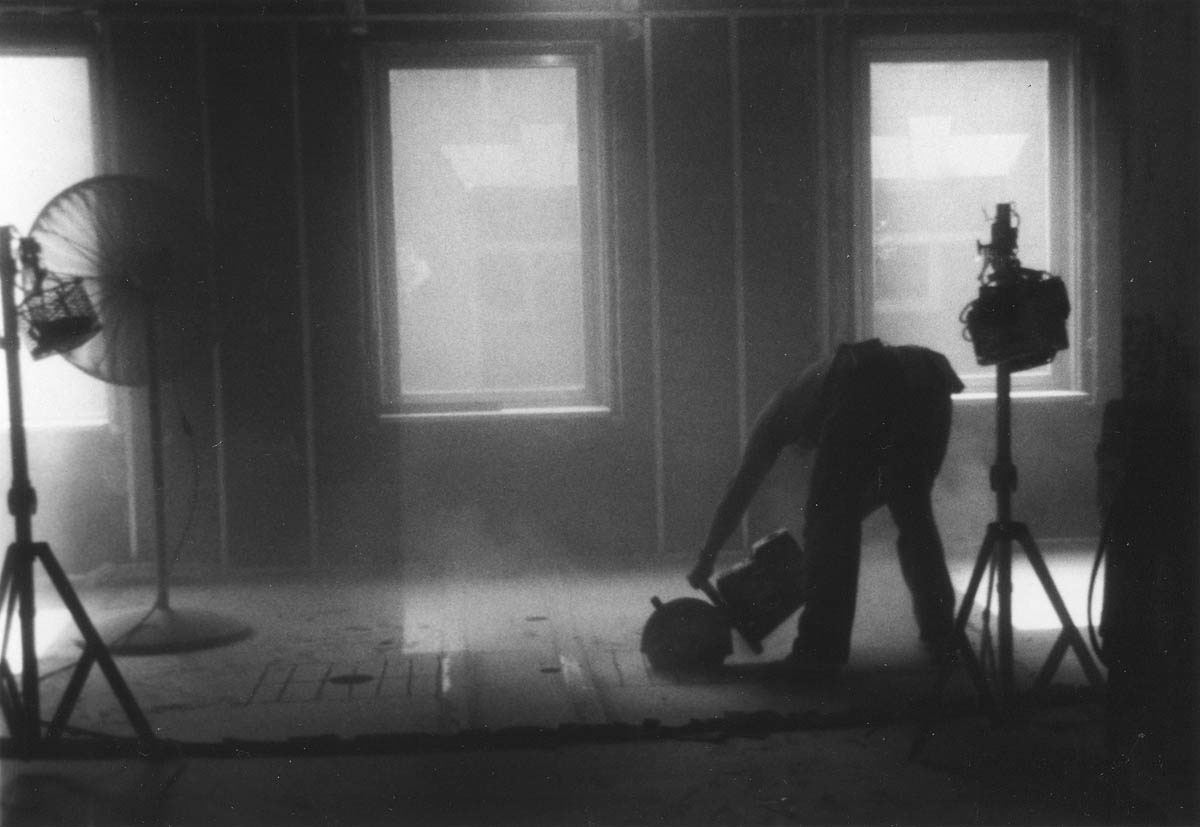 A cloud of dust containing harmful crystalline silica envelops a plumber sawing a concrete floor. Silicosis, a progressively debilitating, incurable disease of the lungs caused by inhaling silica dust, is common among workers in mining, foundries, shipyards, and construction.