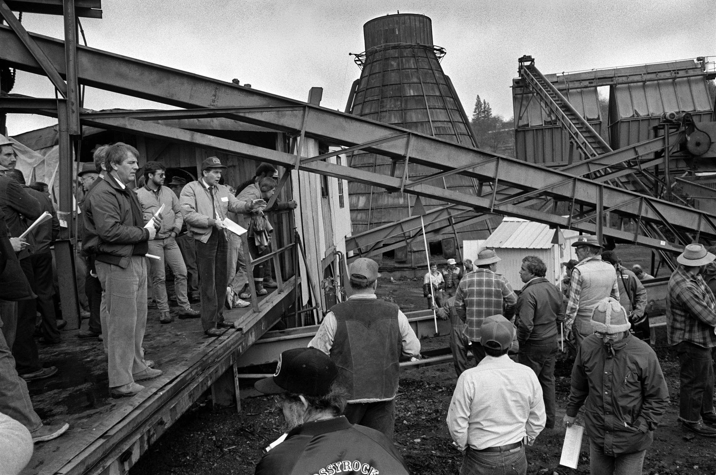 A northern California lumber company auctions off its works and equipment in the fall of 1988. A wave of California mill closings occurred during the 1980s as giant building material and paper corporations, such as Louisiana Pacific and Georgia Pacific, moved their operations abroad.