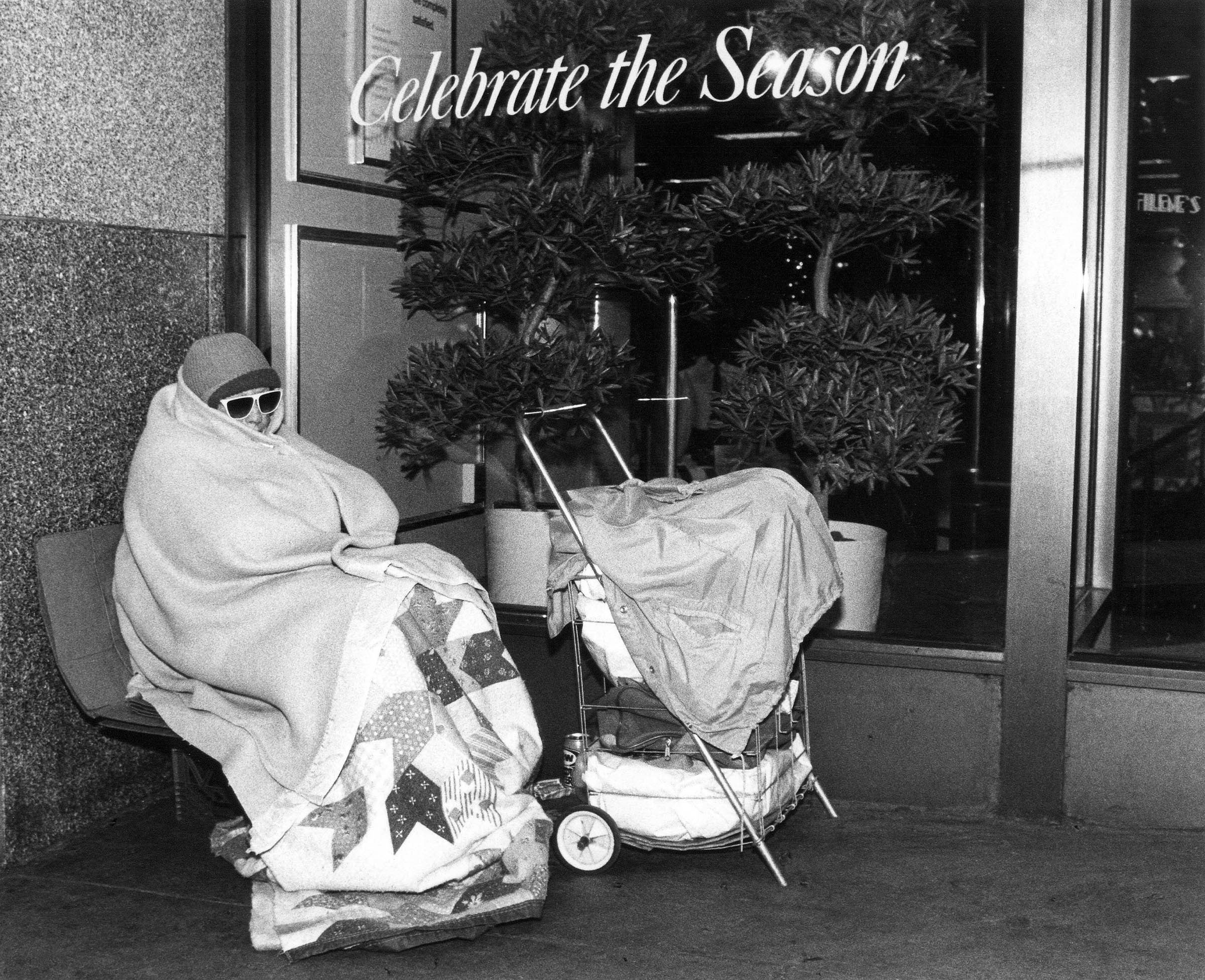 In November 1989, an unhoused woman finds meager shelter outside of Filene’s Department Store in downtown Boston.