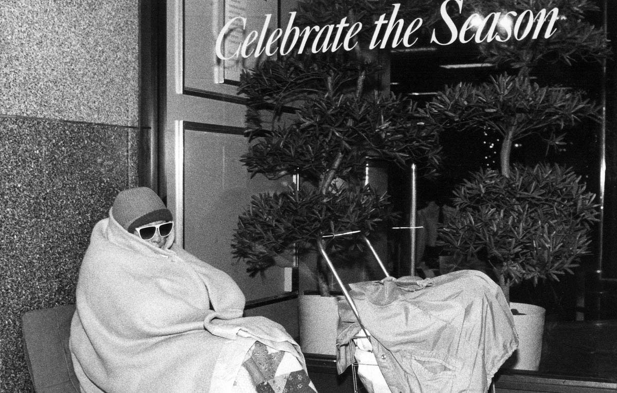 In November 1989, an unhoused woman finds meager shelter outside of Filene’s Department Store in downtown Boston.