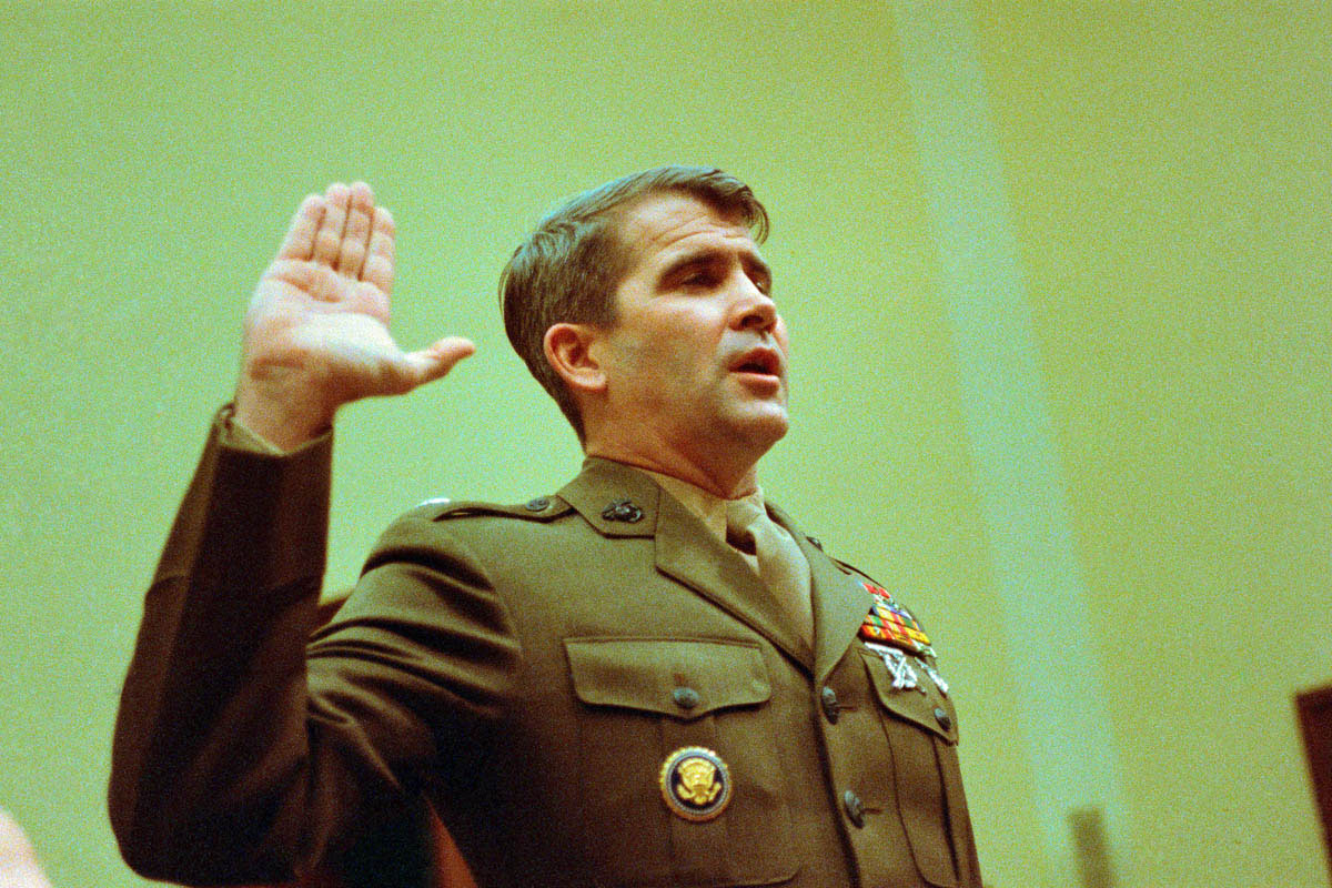 Oliver North appeared before the House Foreign Affairs Committee, which had called him to testify about his role in the Iran-Contra scandal. Dressed in his Marine uniform, North presented himself as a symbol of American patriotism in an effort to counterbalance his refusal (citing his Fifth Amendment rights) to discuss his illegal activities in the basement of the White House. Many news photographers angled their cameras to shoot North from below, casting him as the hero looking down on his interrogators. (North did eventually testify before the committee in July 1987.)