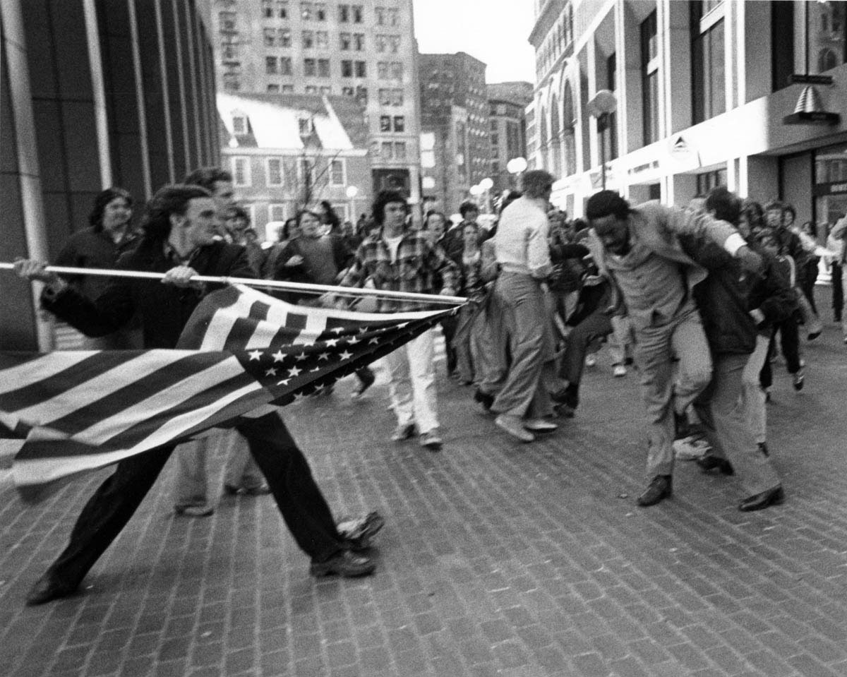 The Boston busing controversy turned violent in the spring of 1976. On April 5, a group of white high school students from South Boston and Charlestown who were opposed to busing visited City Hall to meet with a councilwoman who supported their boycott of classes. Outside the building, the teenagers encountered and then assaulted labor lawyer Theodore Landsmark. The attack sparked a series of violent racial incidents that extended into the summer.