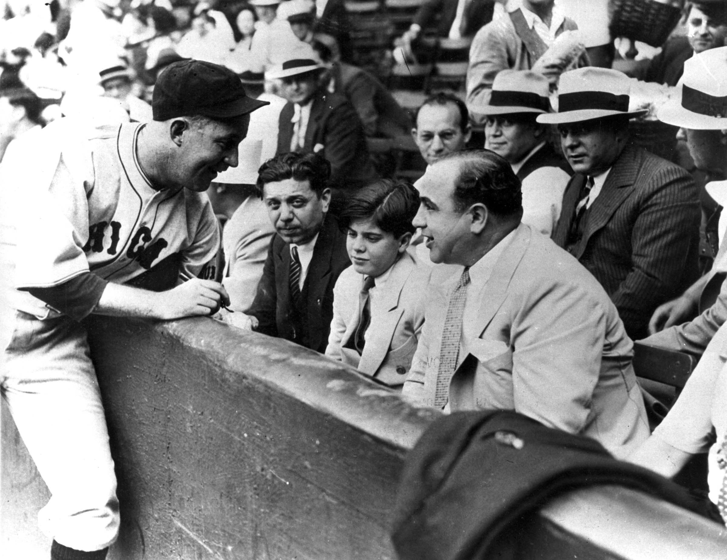 Catcher Gabby Hartnett was photographed as he exchanged pleasantries with “Scarface” Al Capone (who was known to wield a bat himself on occasion). The Chicago Cubs player was autographing a baseball for the gangster’s twelve-year-old son at a charity game in Comiskey Park.