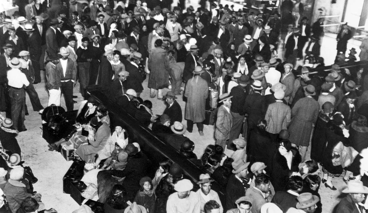 The Mexican population of Los Angeles increased from 34,000 to 97,000 over the 1920s. But the mass unemployment and growing discrimination of the 1930s led to the forced repatriation of tens of thousands as Los Angeles officials and federal agencies initiated schemes to return immigrants to Mexico. A highly publicized sweep took place at Los Angeles Plaza in February 1931. The Mexican government also aided the repatriation campaign. Most returnees left by rail, such as these men, women, and children who gathered at Los Angeles’s Union Station on May 9, 1932.