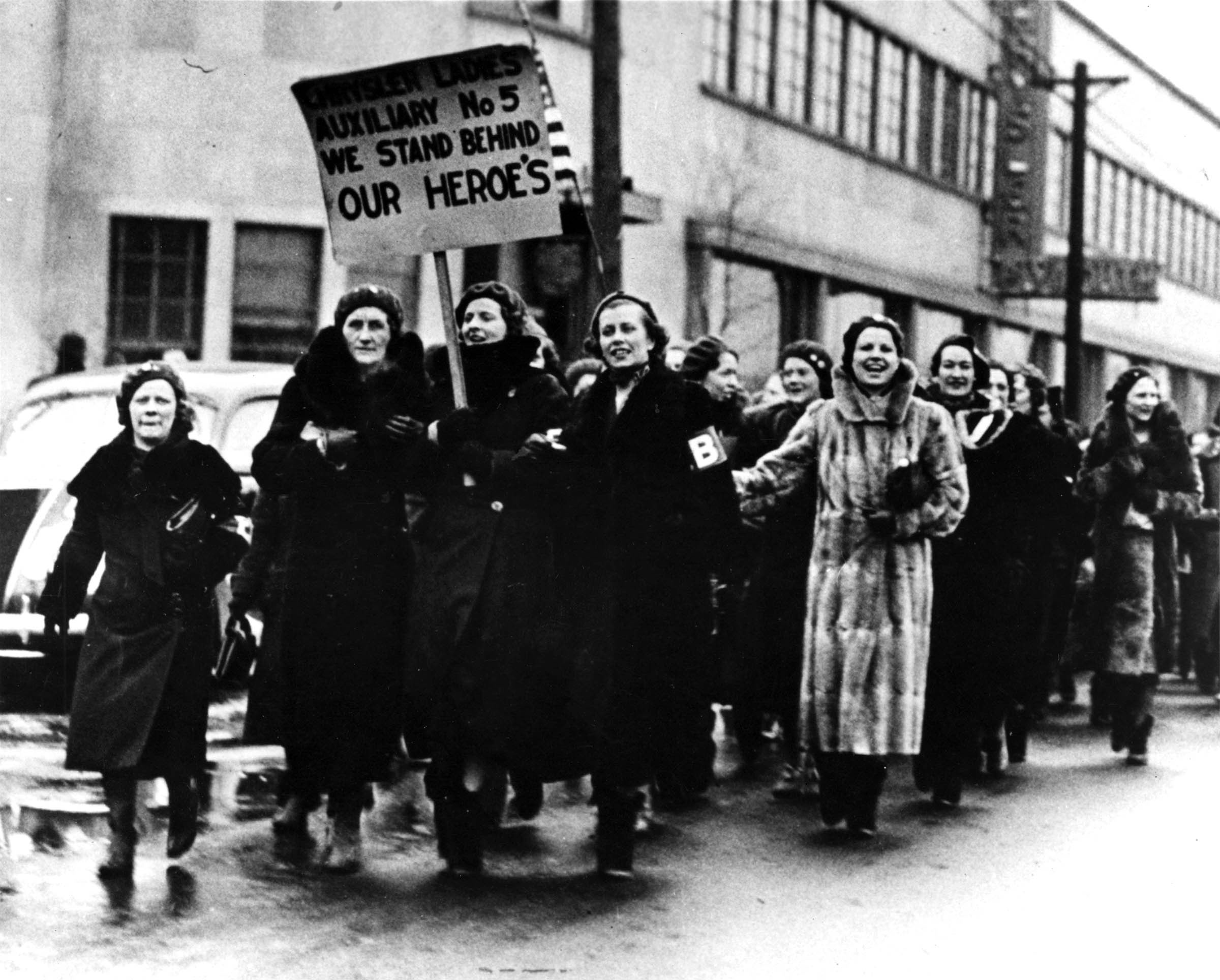 The UAW’s Women’s Emergency Brigade, along with members of the union local’s Women’s Auxiliary, marched in front of an occupied Chrysler plant in March 1937.